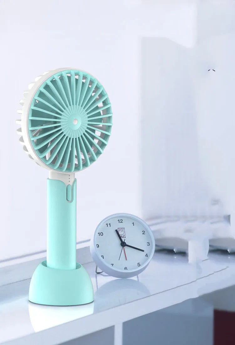 Blue mini handheld USB electric fan with three-speed control on a desk