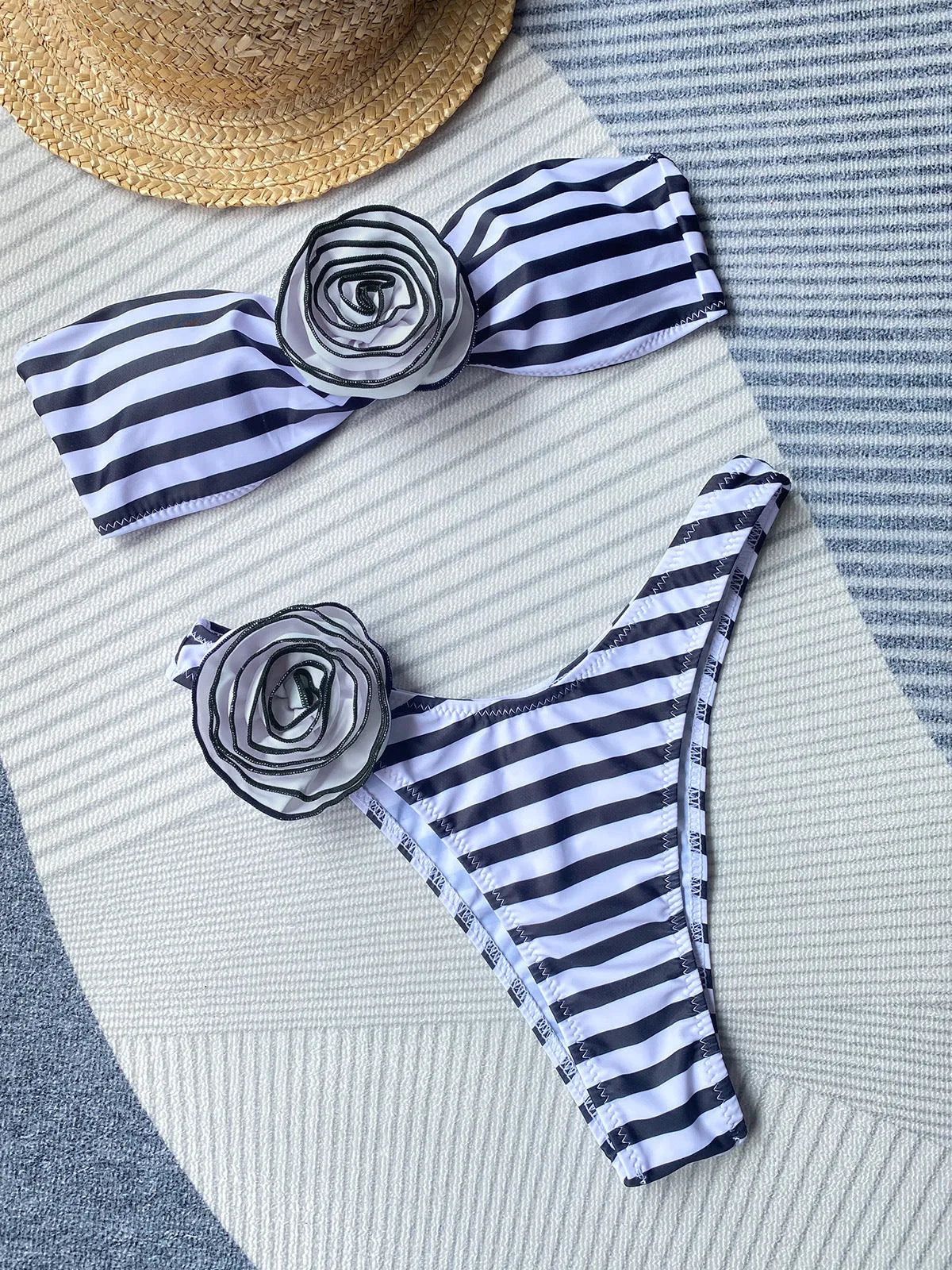 Striped bikini swimsuit with three-dimensional flower detail and split design, includes tube top and shorts.