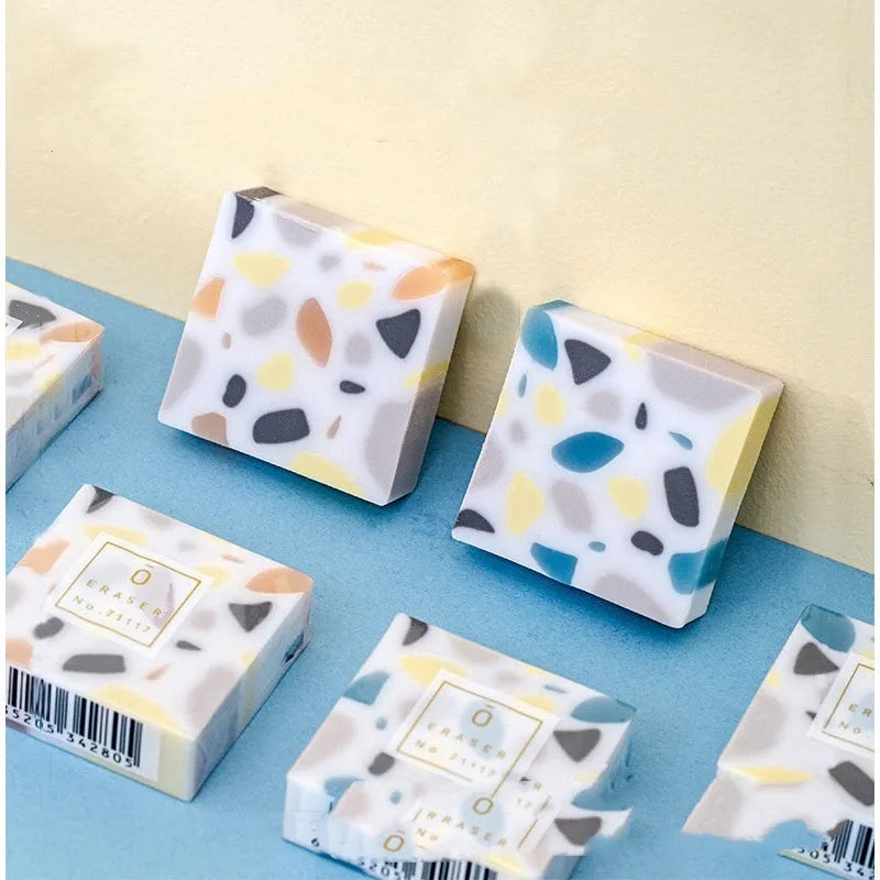 White brick-shaped rubber eraser on a flat surface.
