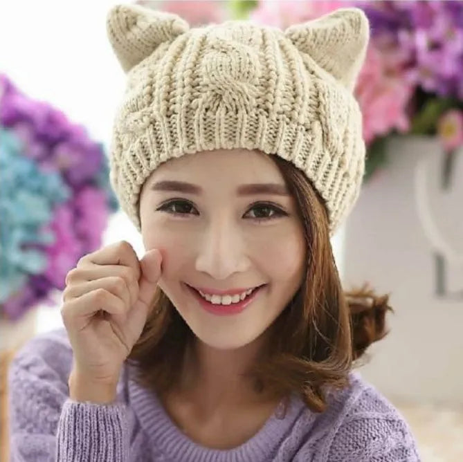 Handmade red knitted beanie with 3D cat ears on a white background