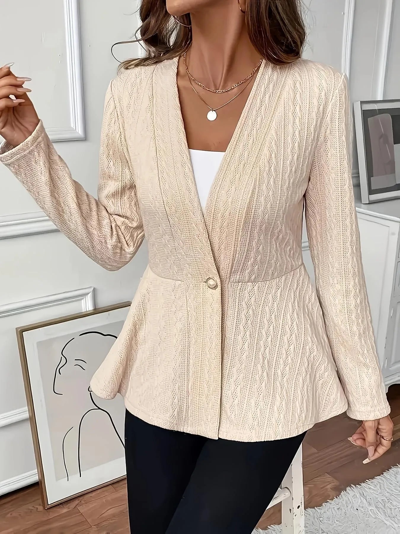 Women's apricot tight-fit Jacquard knitted cardigan with one button on a hanger.