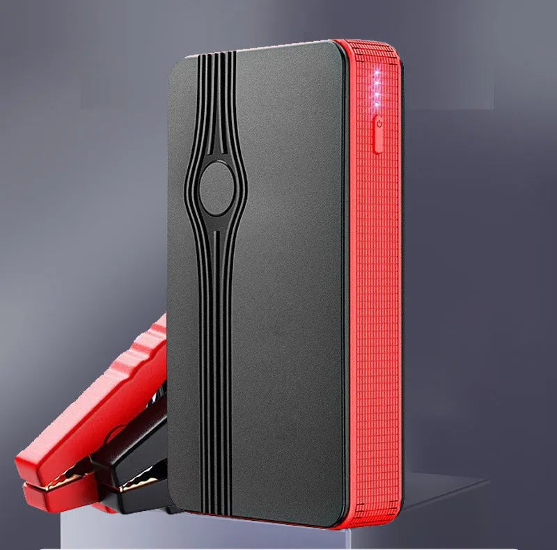 Red K4-E automobile emergency starting power supply and USB power bank unit on a grey surface.