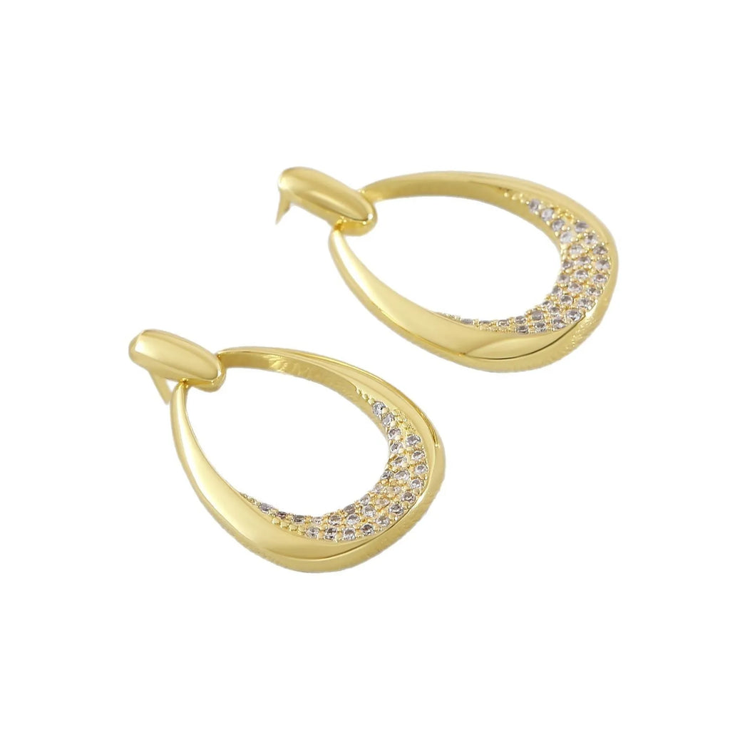 Yellow gold geometric drop earrings with oval and round ring elements on copper
