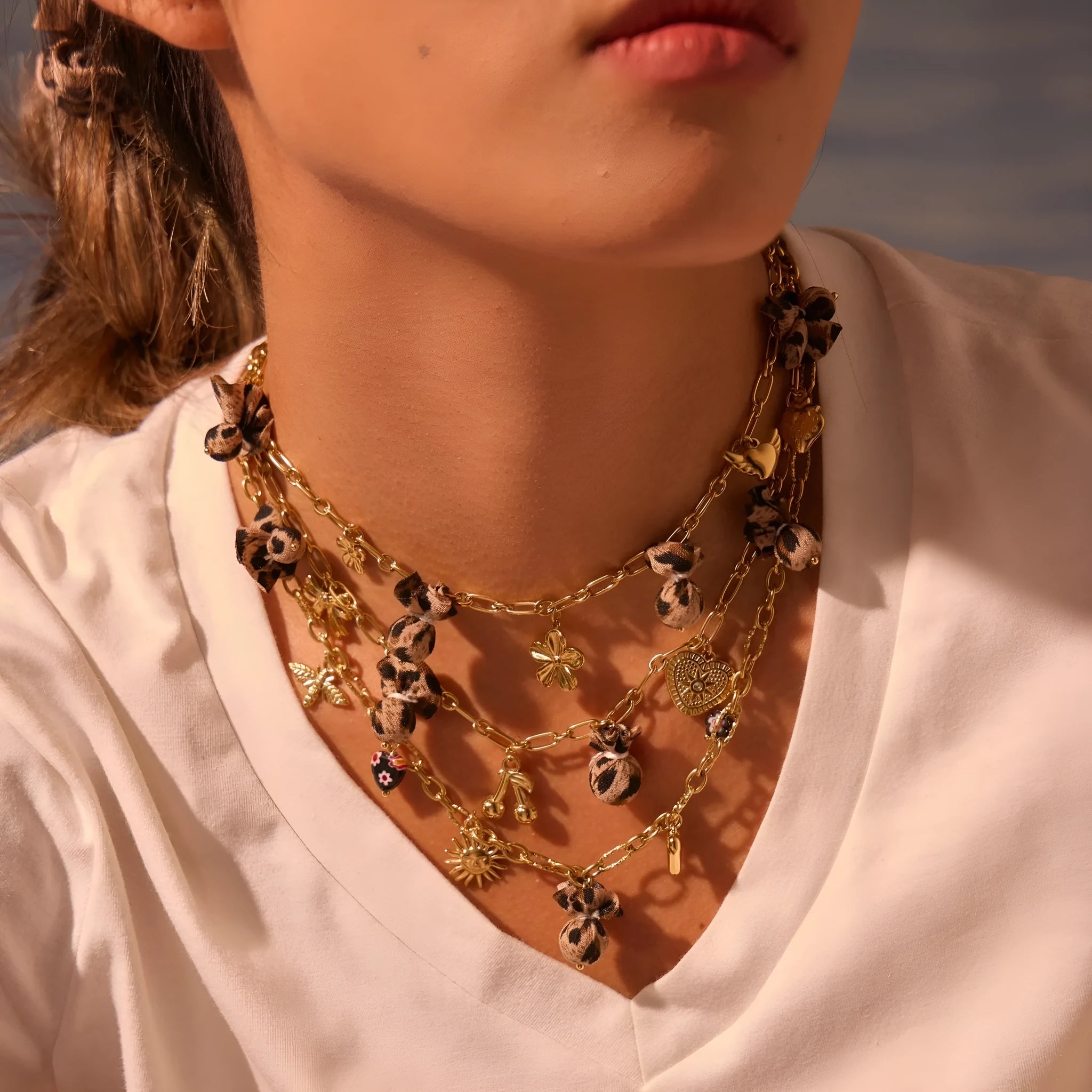 Gold-plated leopard pendant necklace with love heart and flower detailing on adjustable chain