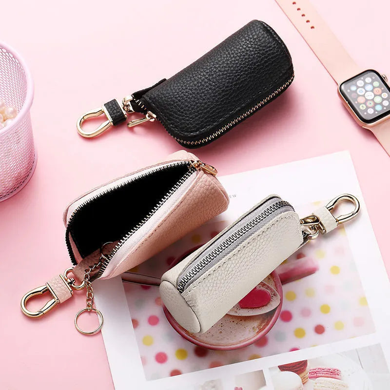 Simple black PU leather zipper key ring case on a grey background.