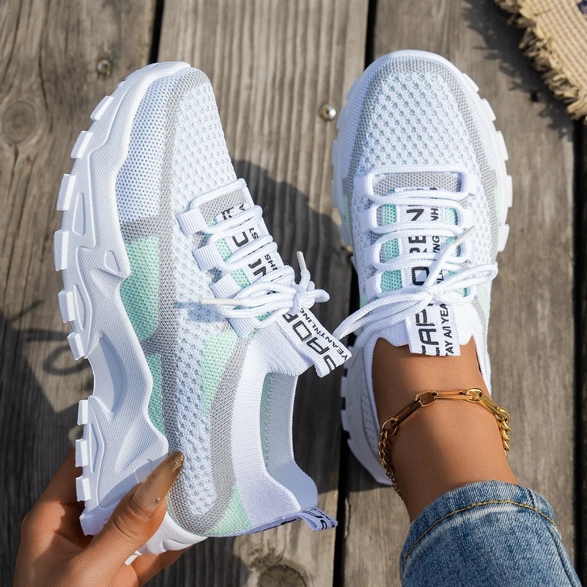 Women's Flyknit mesh lace-up sneaker in a grey colourway, showing the breathable upper and rubber sole.