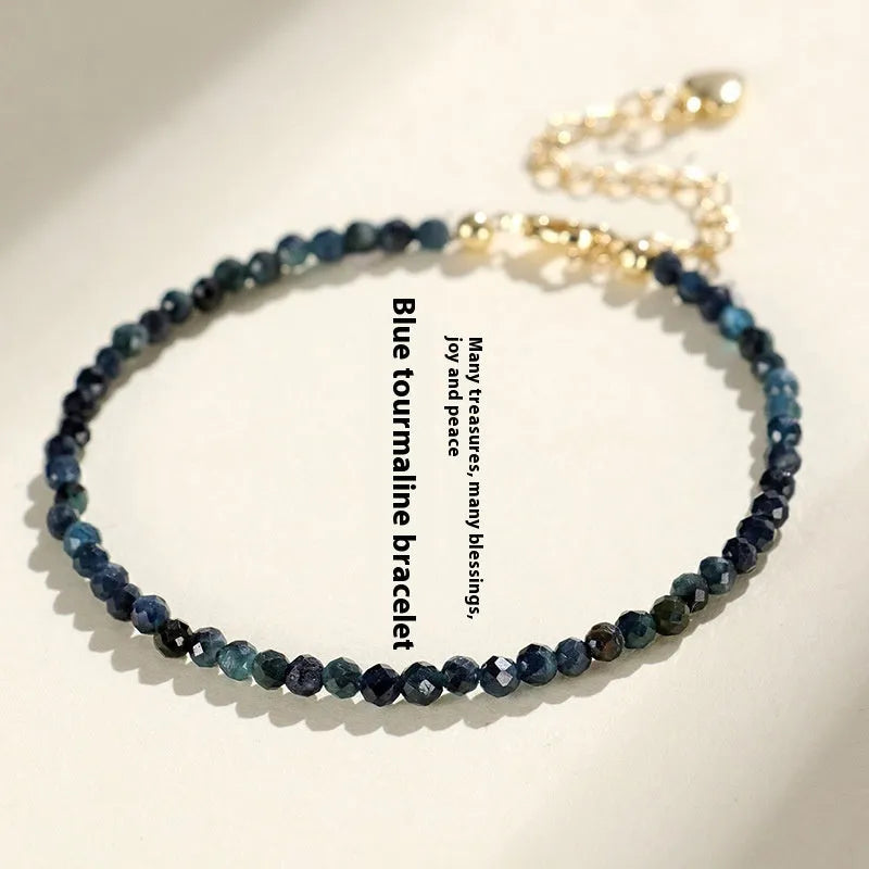 Close-up of a women's blue tourmaline beaded bracelet with 3mm beads and spacer sections.