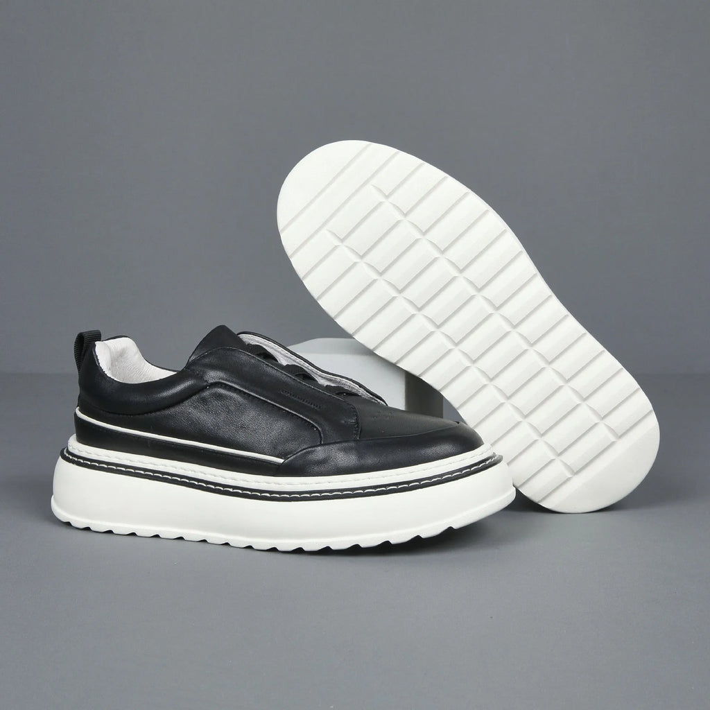 Black leather low-top slip-on sneaker with elastic sides and foam sole on white background