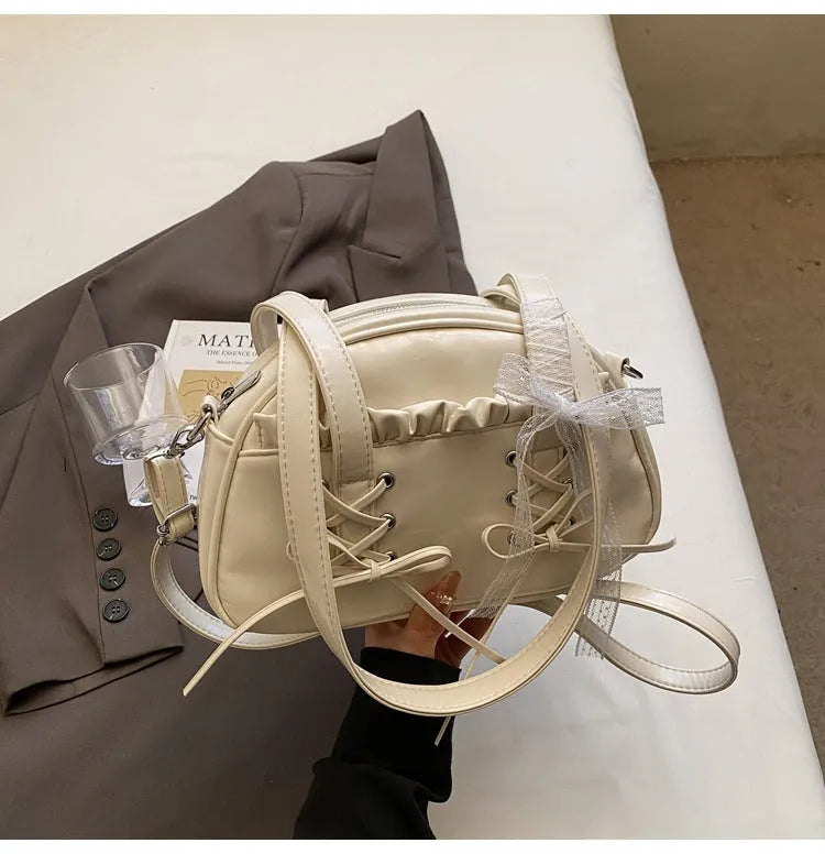 Milky white women's PU leather shoulder bag with a removable bandage bow and visible sewing thread detailing