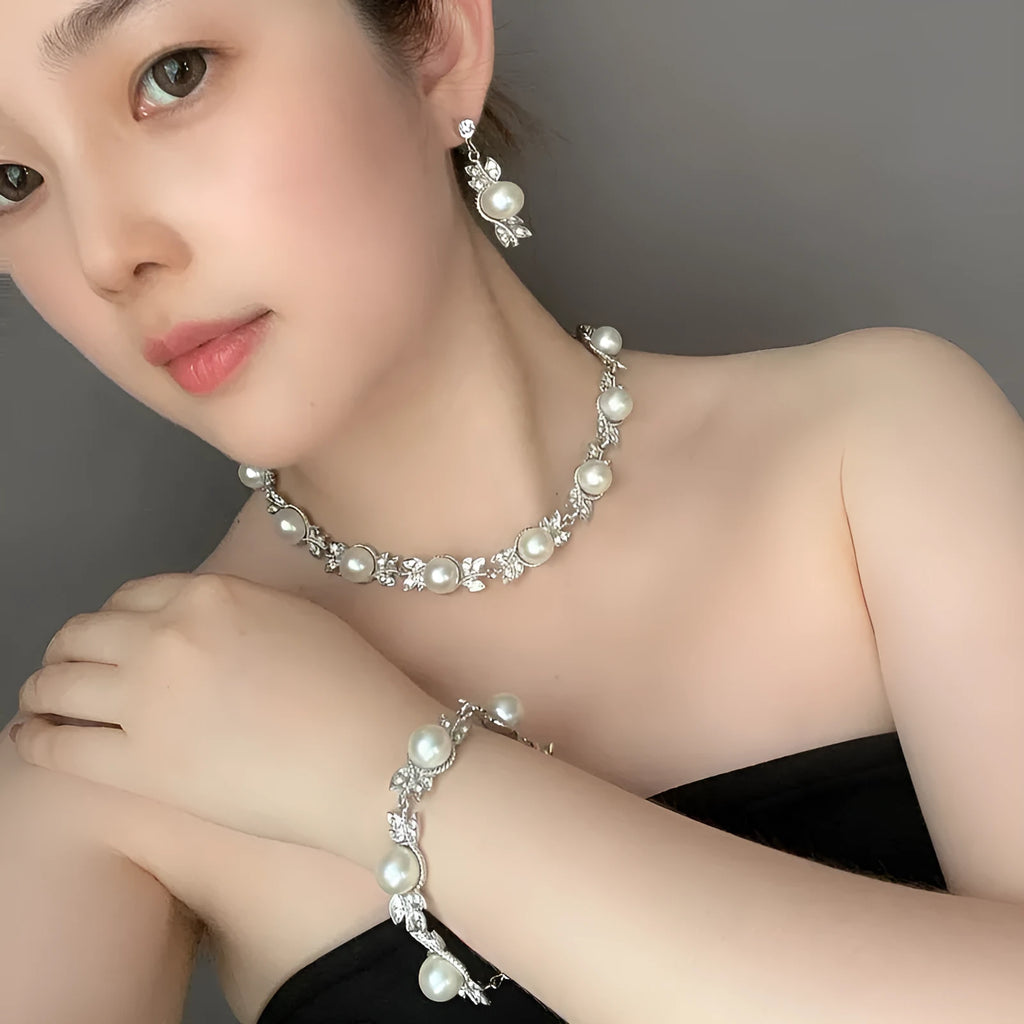Three-piece jewellery set with rhinestone and pearl necklace, earrings, and bracelet in silver finish
