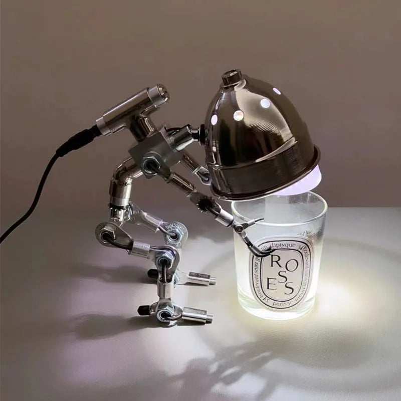 Silver copper robot-shaped atmosphere light with graphic customisation on a desk.