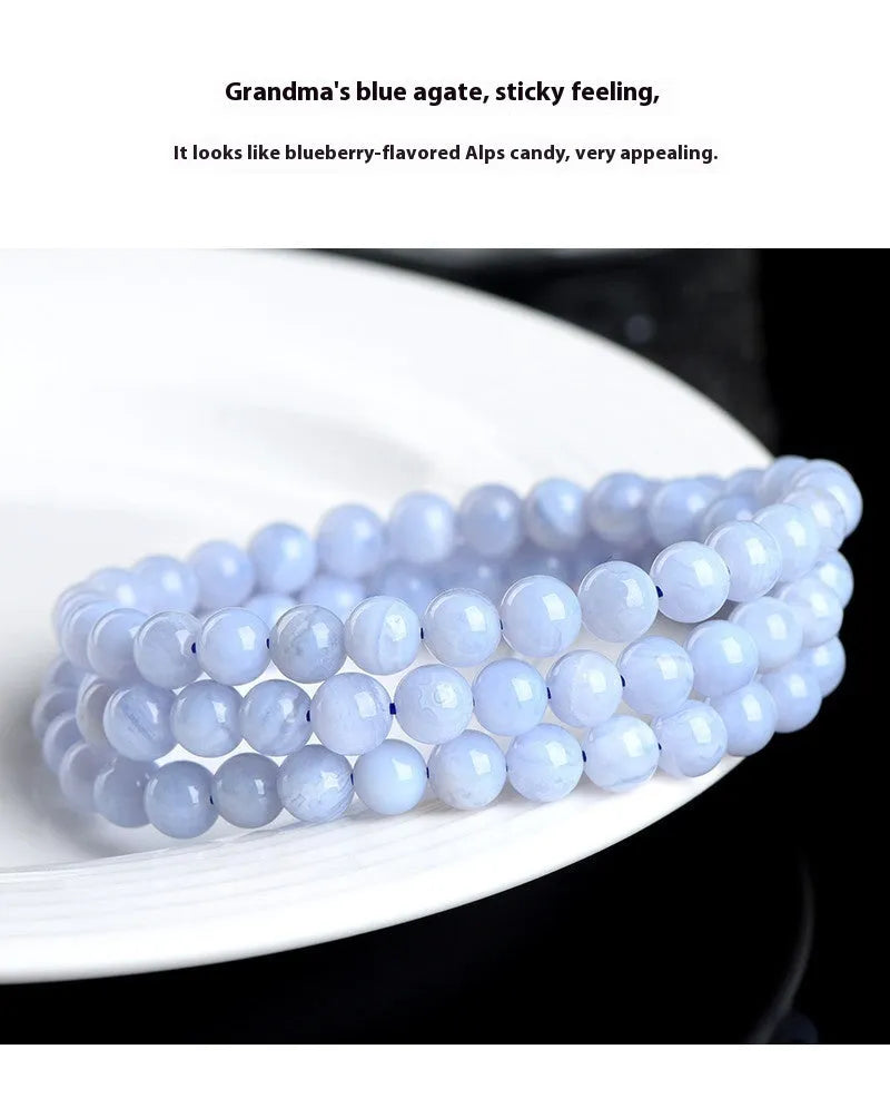 Blue agate bracelet with scattered beads pattern and a Ruyi charm on a white background.