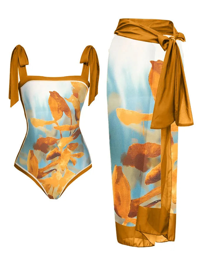 Women's floral print two-piece swimsuit with a blue chiffon skirt laid flat.