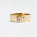 Gold electroplated women's ring with a shining zircon stone, shown on a finger.