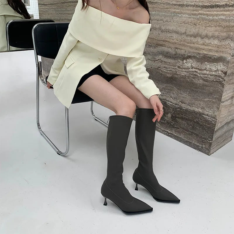 Black pointed toe below the knee stiletto heel boots with a back zipper fastening.