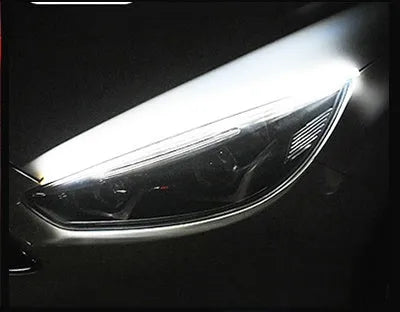 Flexible silicone car LED daytime running light strip with flowing turn signal animation mounted on headlight.