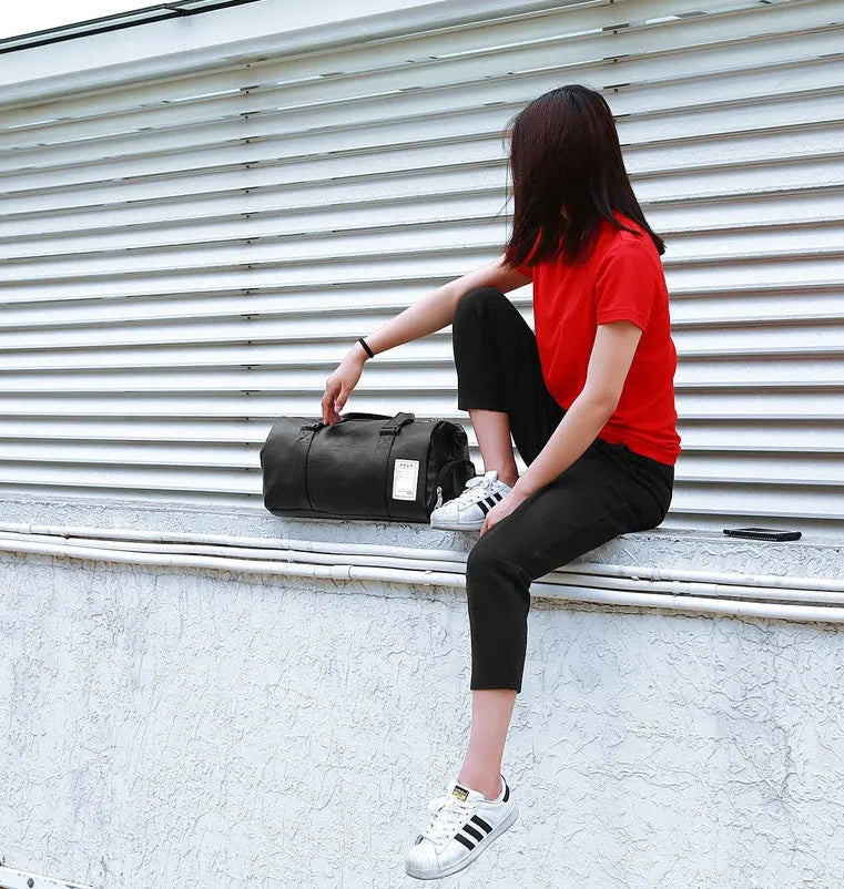 Black waterproof sports bag with diagonal straps and separate side shoe compartments.