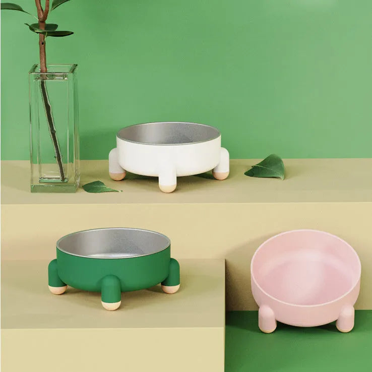 Green stainless steel pet bowl with non-slip base and high foot design on a wooden floor