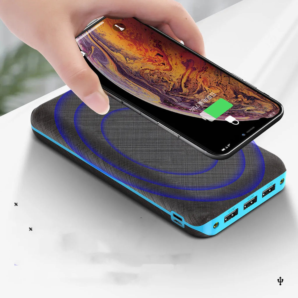 Black portable power bank with solar panel, wireless charging surface, and three USB output ports