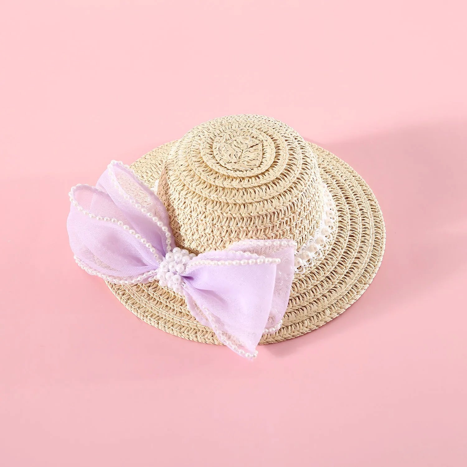 Woven straw hat for a cat with a pearl butterfly bow, shown in pink, purple, blue, or white colour options.