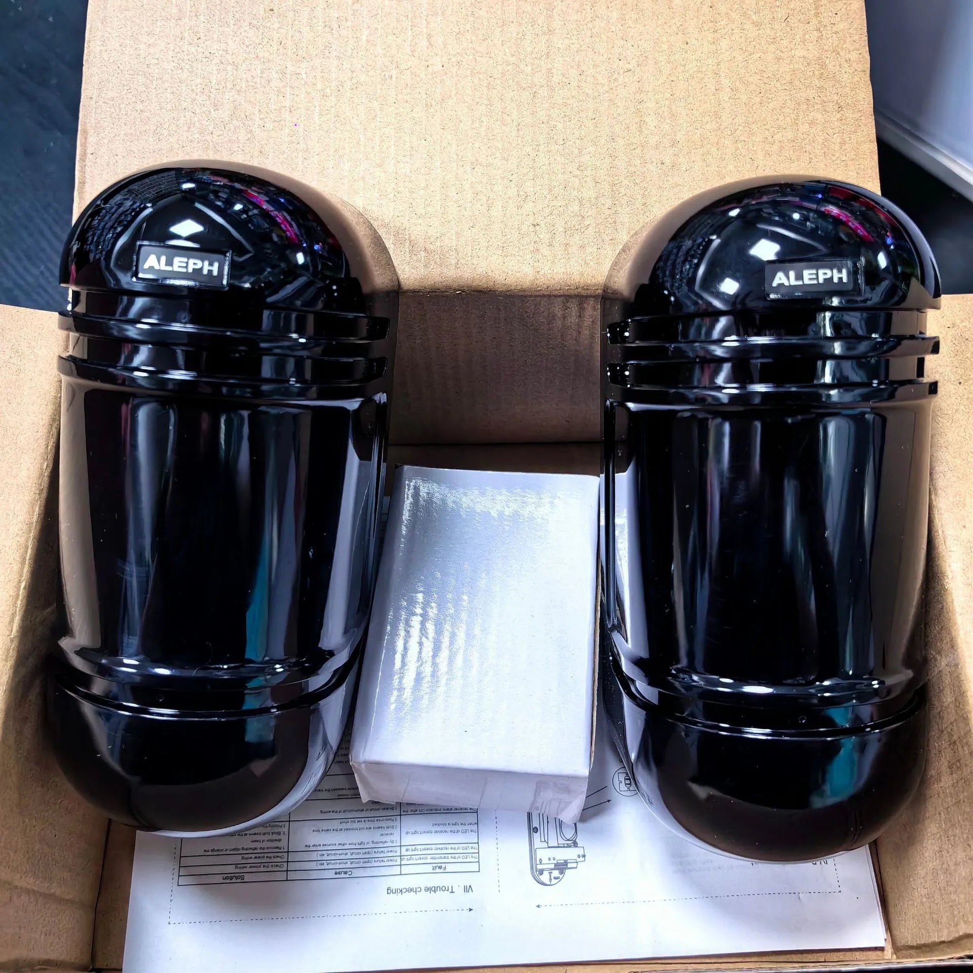 A pair of black wired infrared security detectors for 150-metre perimeter alarm systems.