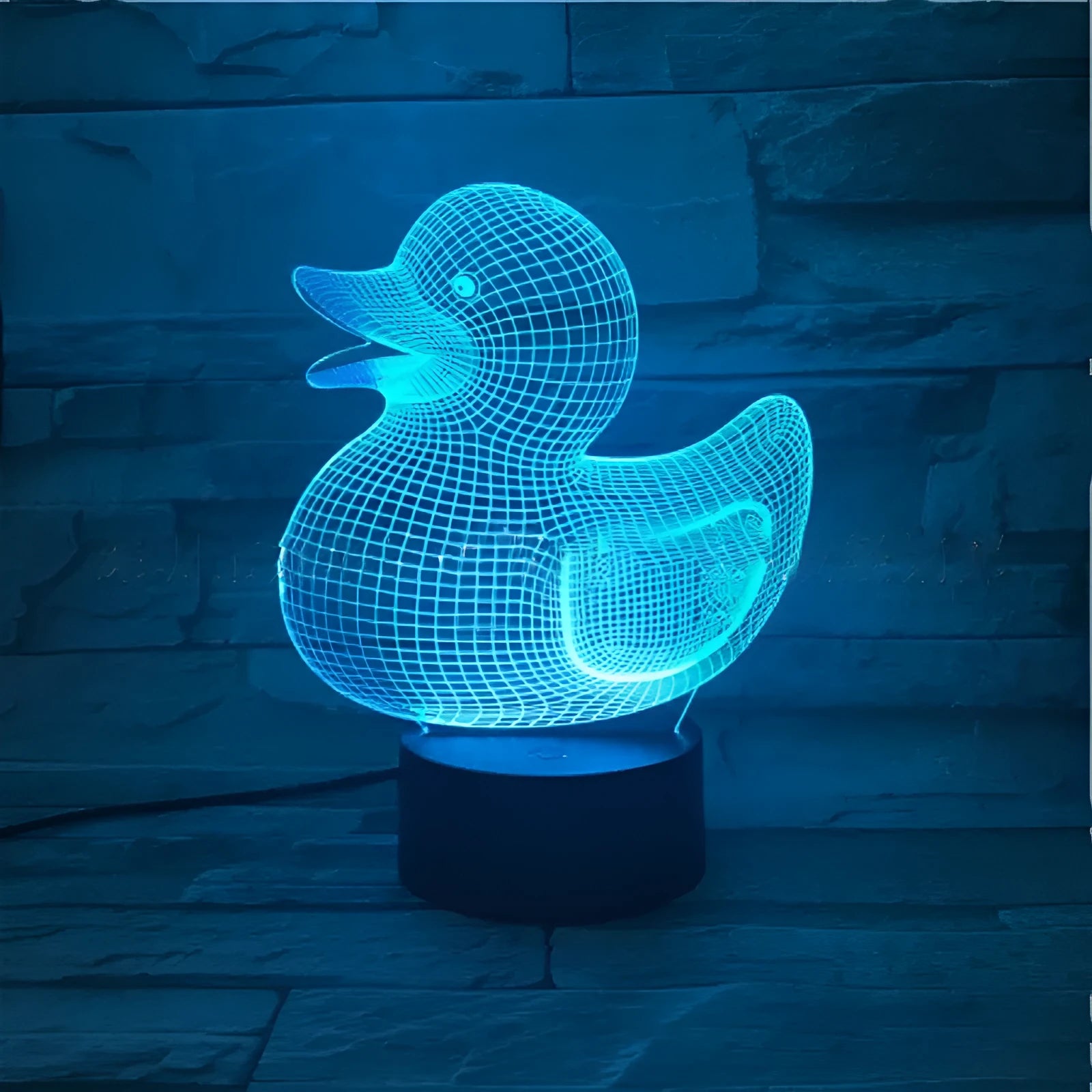 Little yellow duck 3D night light with multi-colour LED glow on an ABS base, showing remote control.