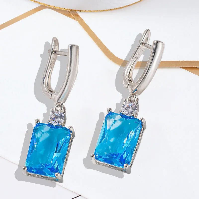 A pair of square geometric stud earrings with a quadrilateral design in an electroplated gold or silver finish.