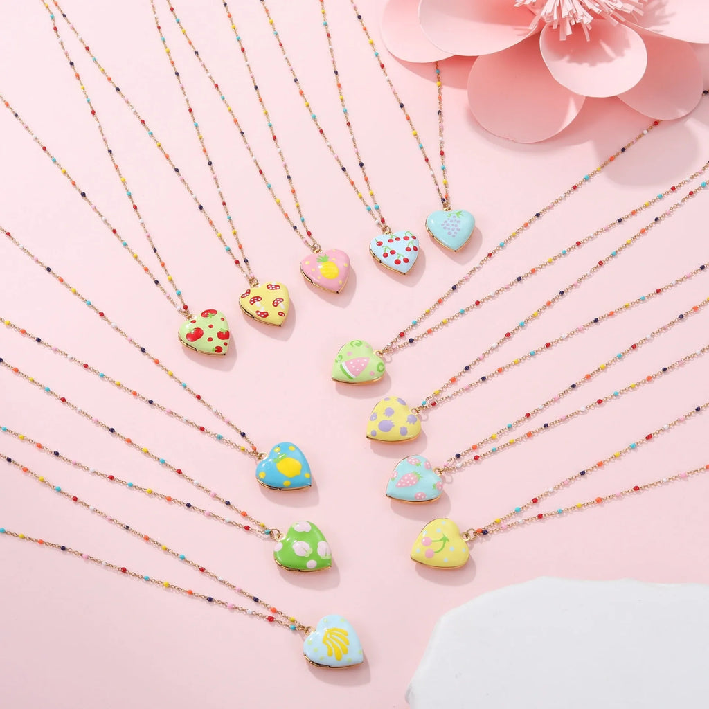 Gold-plated heart-shaped fruit pendant necklace on a stainless steel chain, showing grape design detail.