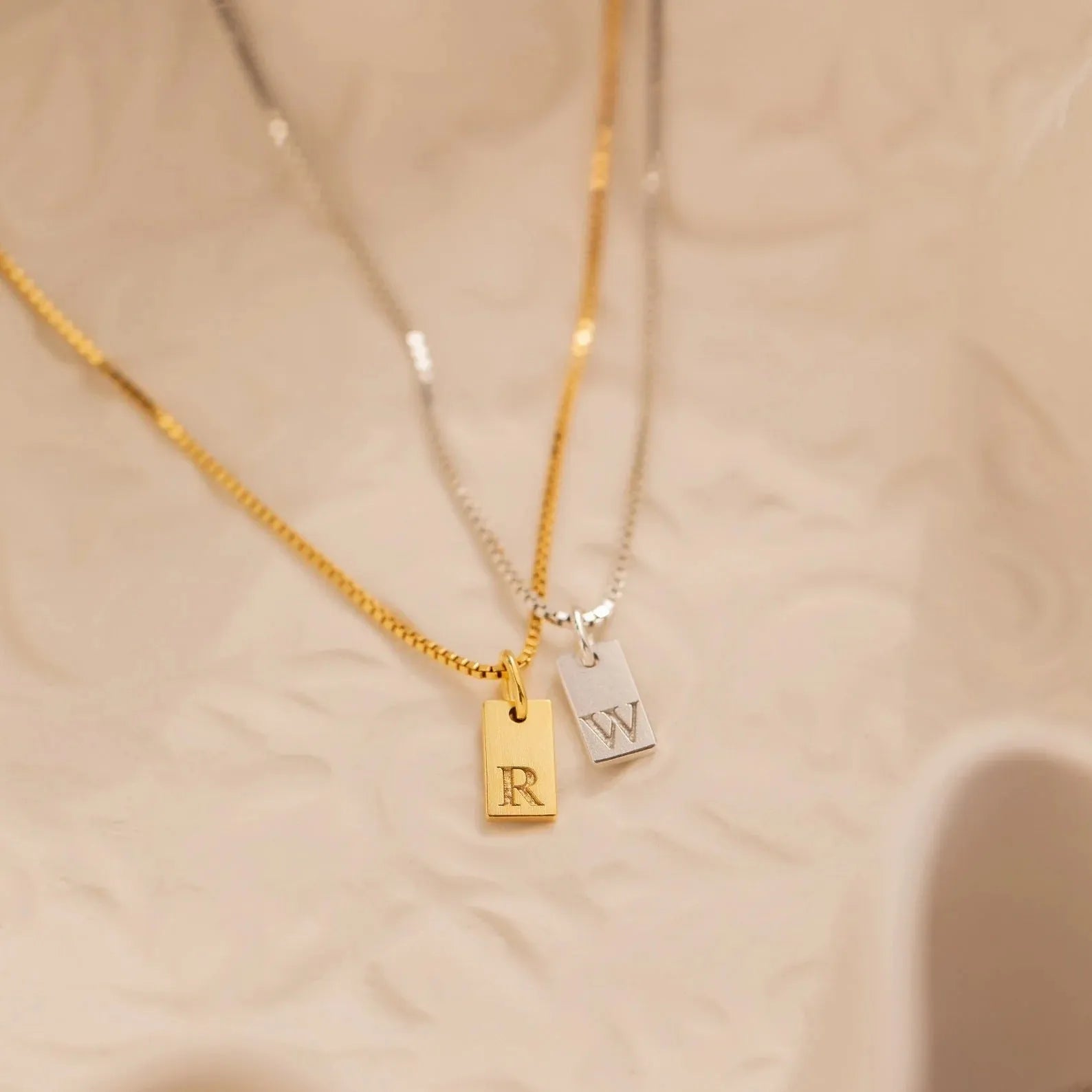 Mini square stainless steel initial necklace with gold plating on a sparkling box chain