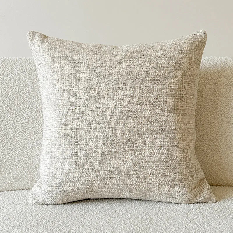 American-style jacquard cushion cover with paisley and flower pattern in amber colours on a sofa.