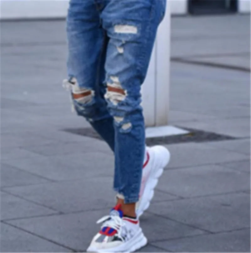 Men's deep blue jeans with distressed hole detailing on cotton denim fabric