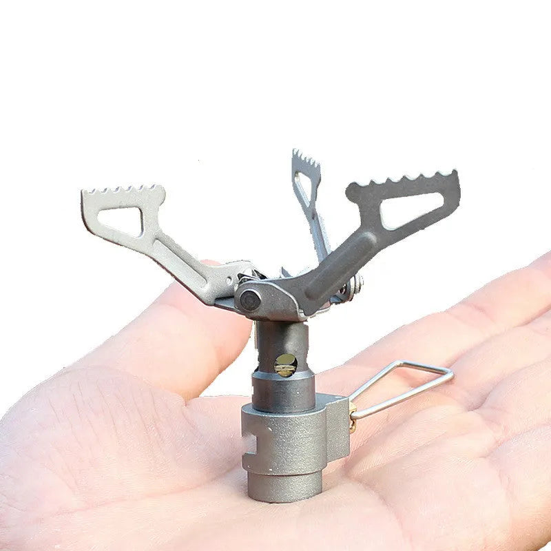 A portable single-burner propane camping stove with a one-piece metal furnace, shown outdoors.