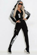 Black women's casual suit with hooded zip-up jacket and matching printed trousers on a hanger.