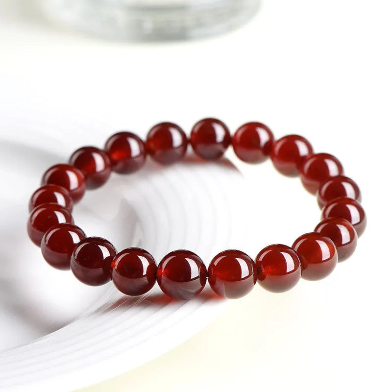 Natural orange red garnet crystal bracelet with Ruyi design elements on wrist