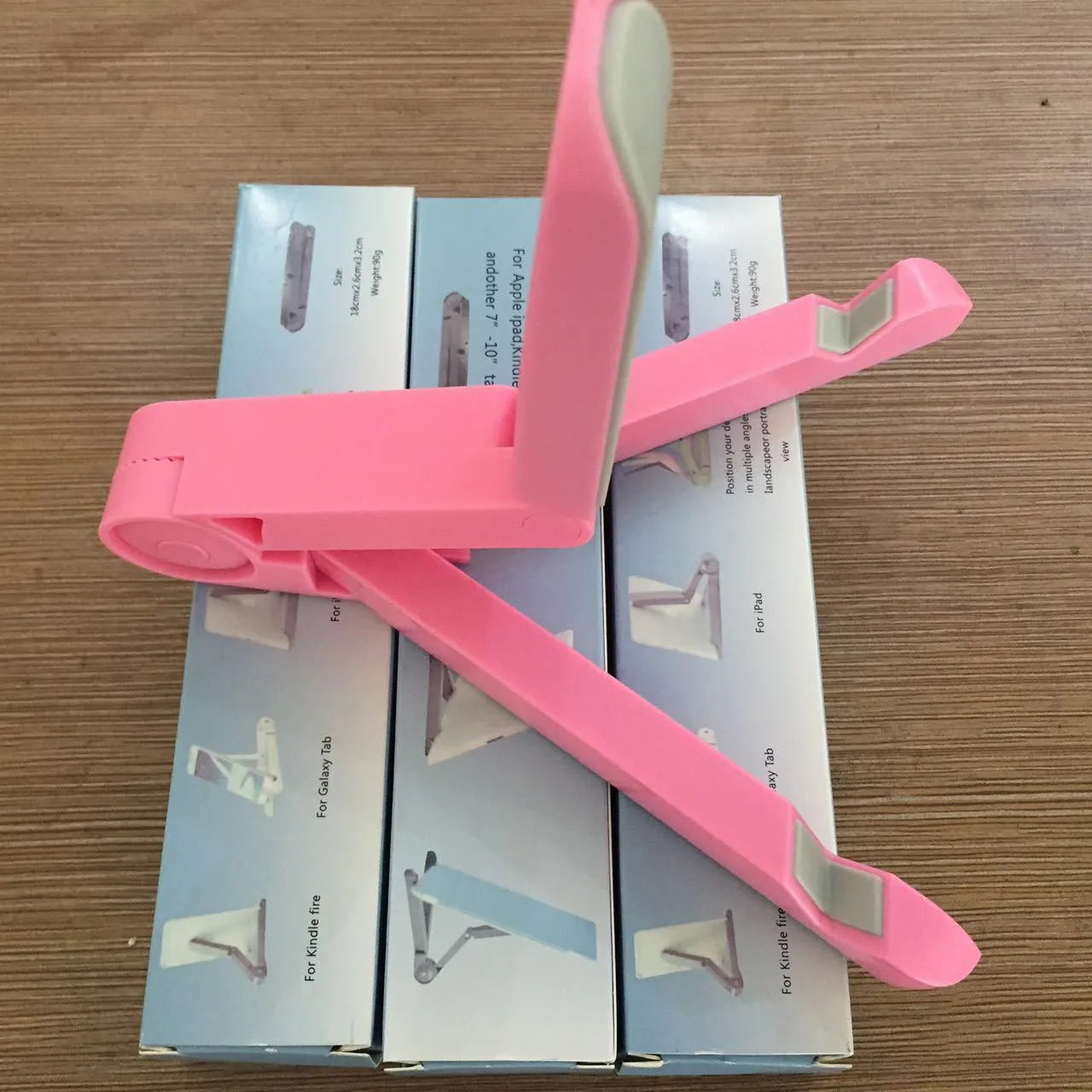Black foldable tablet holder standing upright with a tablet device resting on its non-slip rubber surface.