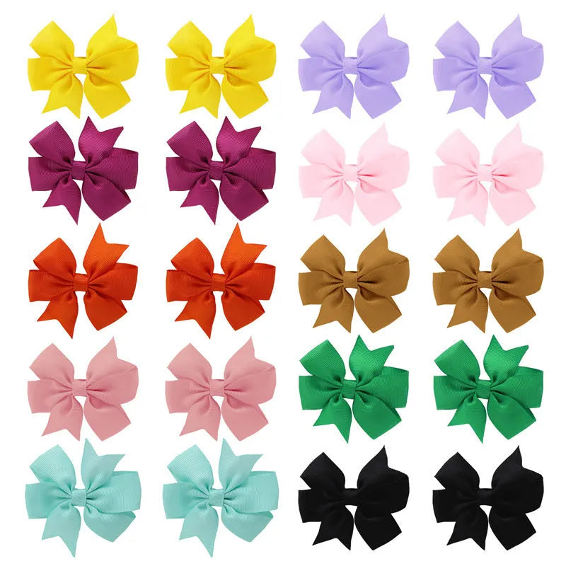 Assorted colours of 3-inch grosgrain ribbon pinwheel hair bows with alligator clips for toddlers.
