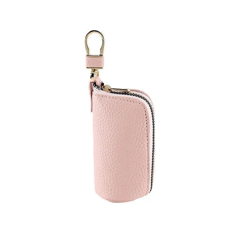 Simple black PU leather zipper key ring case on a grey background.