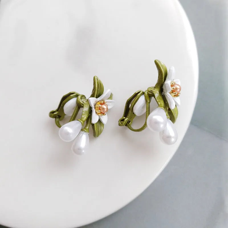 Two pairs of women's floral alloy earrings: one clip-on flower style and one pair of sterling silver needle flower studs.