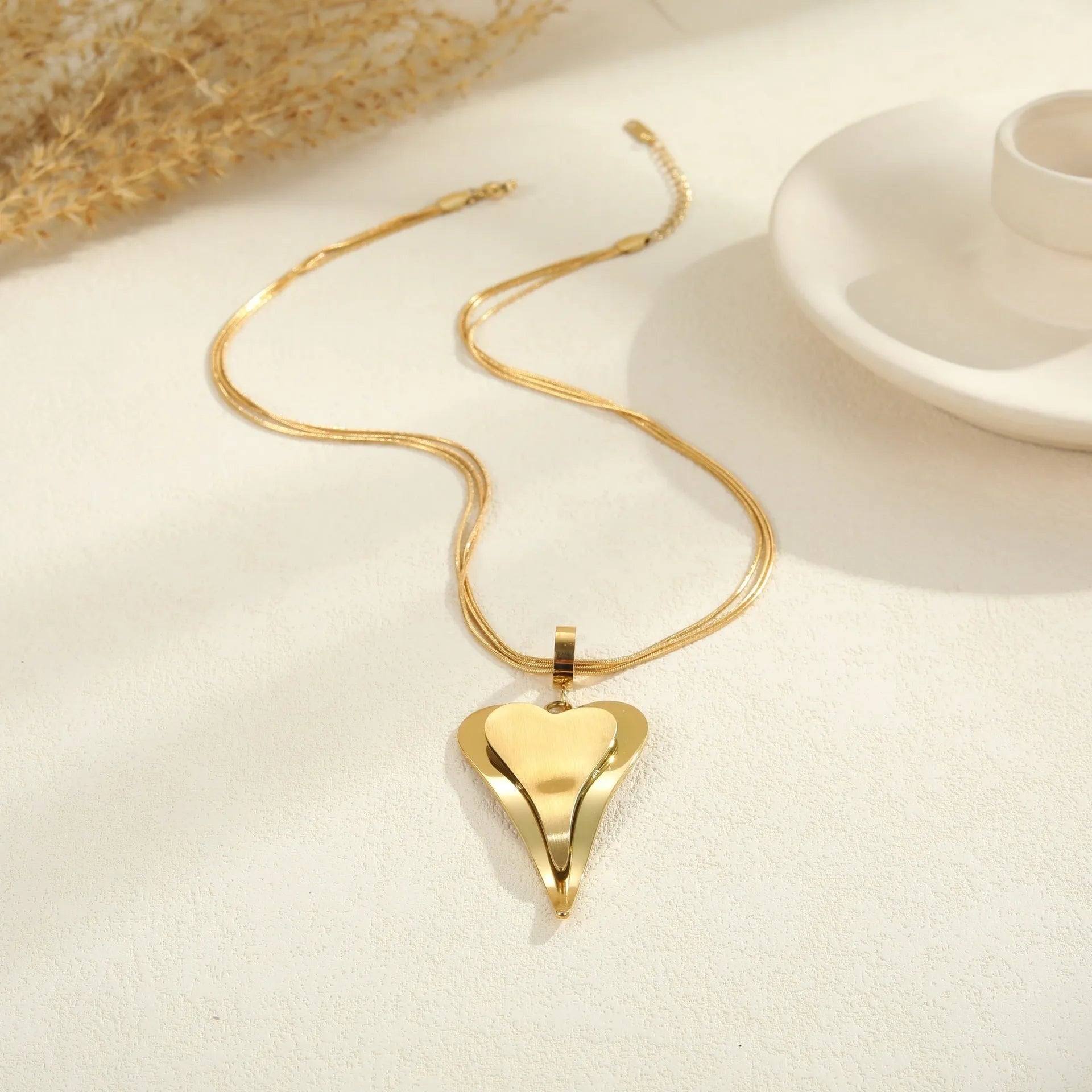 Stainless steel necklace with geometric double heart design formed from snake bones chain elements