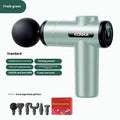 Konka V19 grey mini electric massage gun with multiple attachment heads on a table