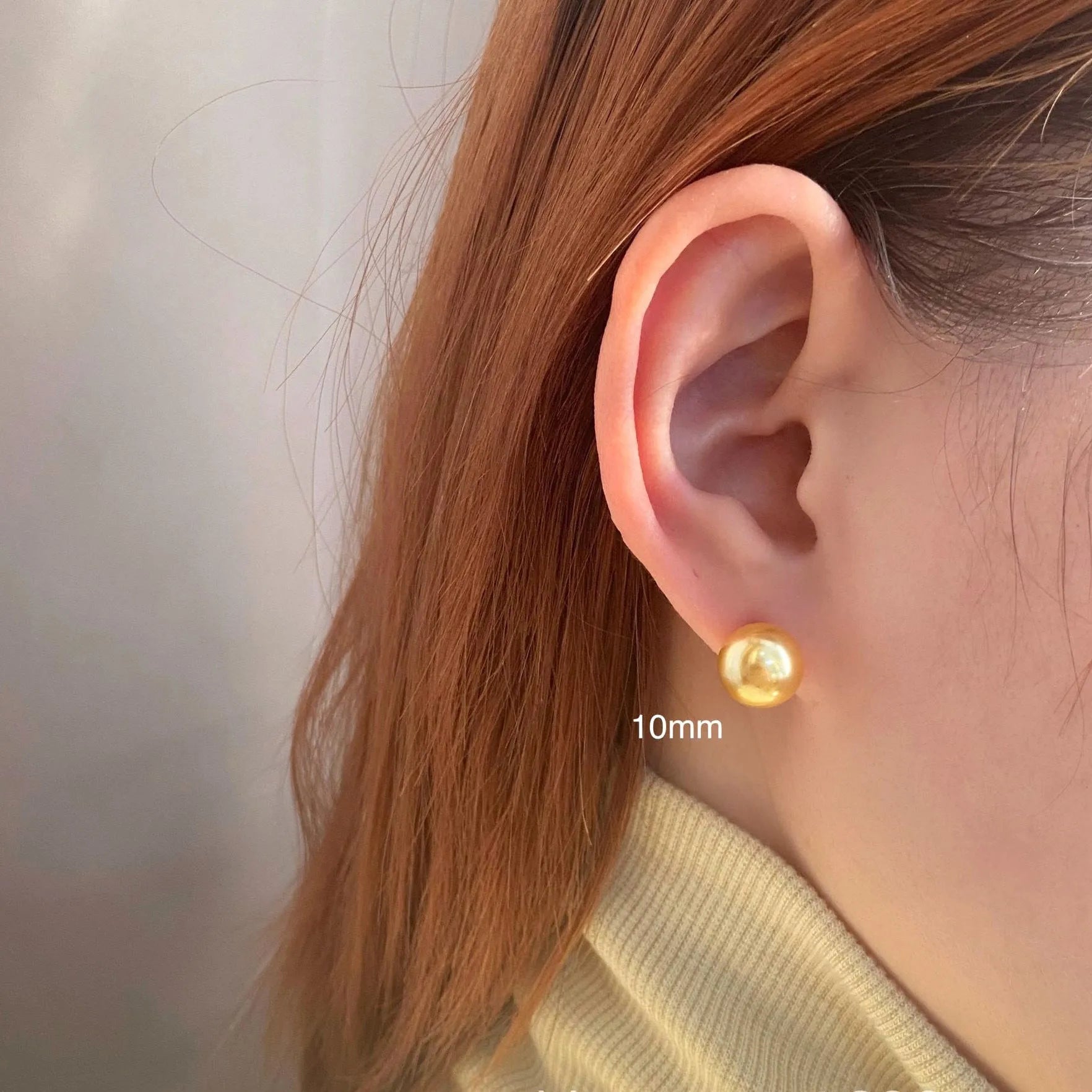 A pair of large silver pearl stud earrings with an eight-pointed star geometric design on a white background.