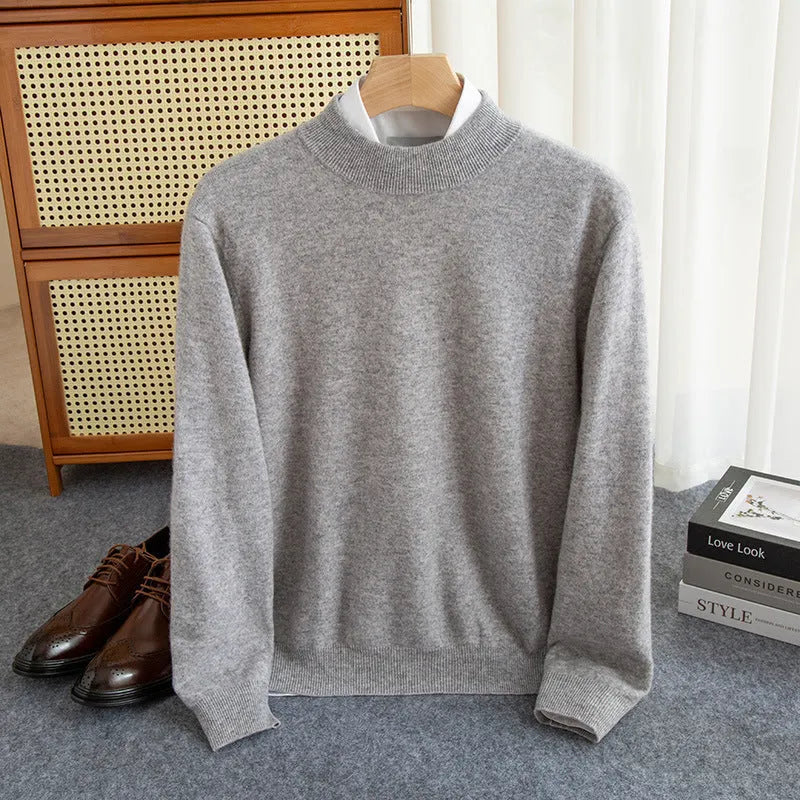 Man wearing a loose-fit, chunky knit wool sweater with a half-turtleneck collar in a neutral colour.