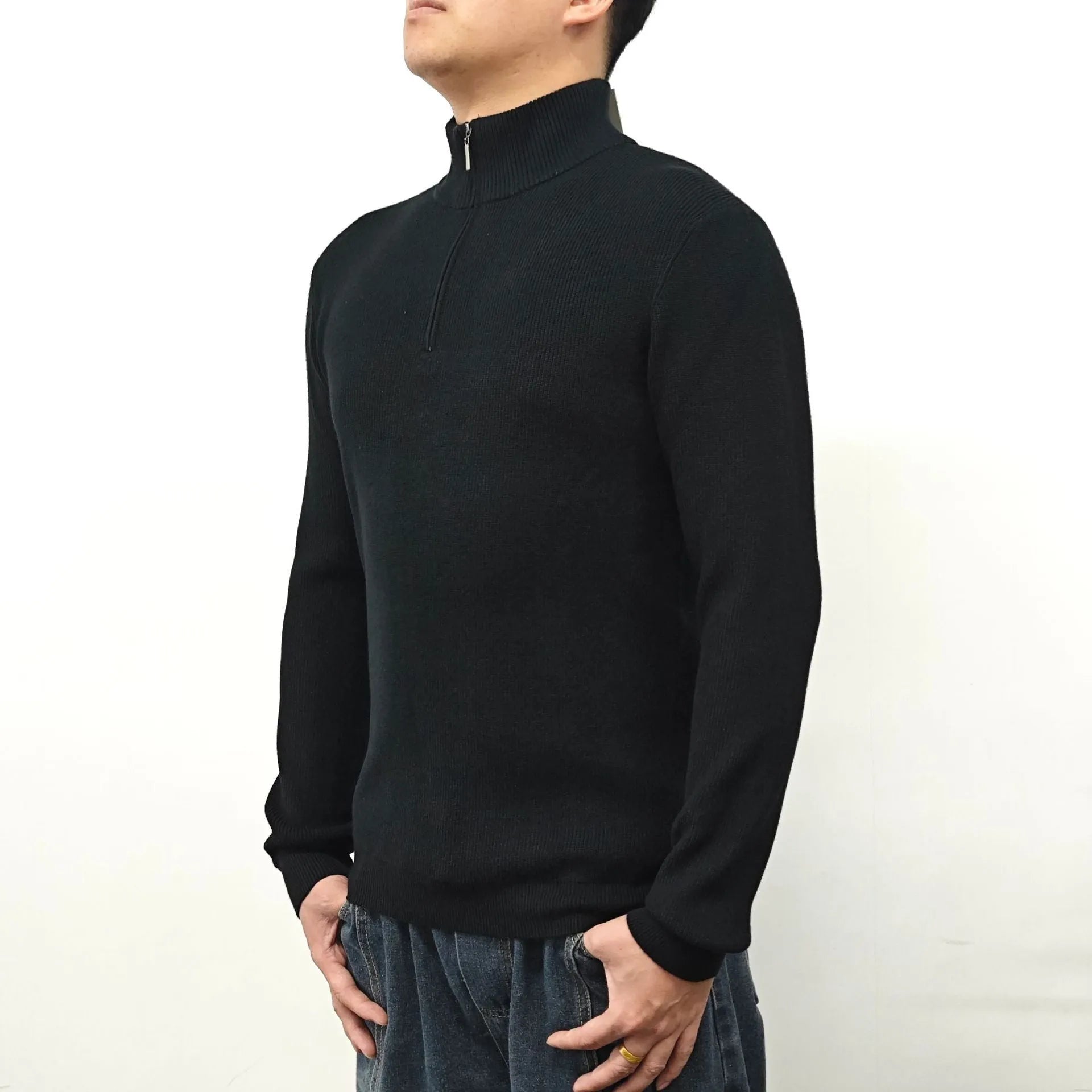 Man wearing a gray zip-front half-turtleneck long sleeve cotton blend sweater.