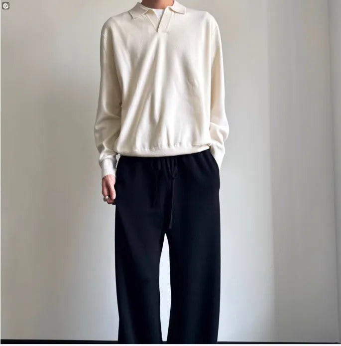 Man wearing a milky white pure wool polo sweater with a lapel collar and loose long sleeves.