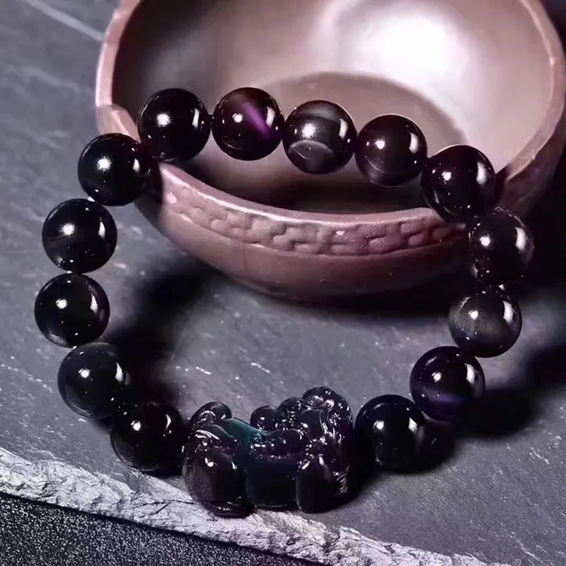 Natural ice colour eye obsidian crystal bracelet with spherical beads on a wrist.