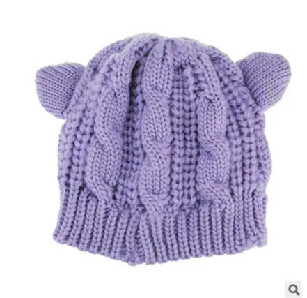 Handmade red knitted beanie with 3D cat ears on a white background