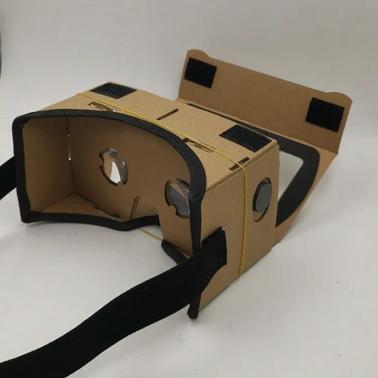 Pink and white cardboard VR glasses headset for smartphones, showing lenses, head strap, and magnetic button.