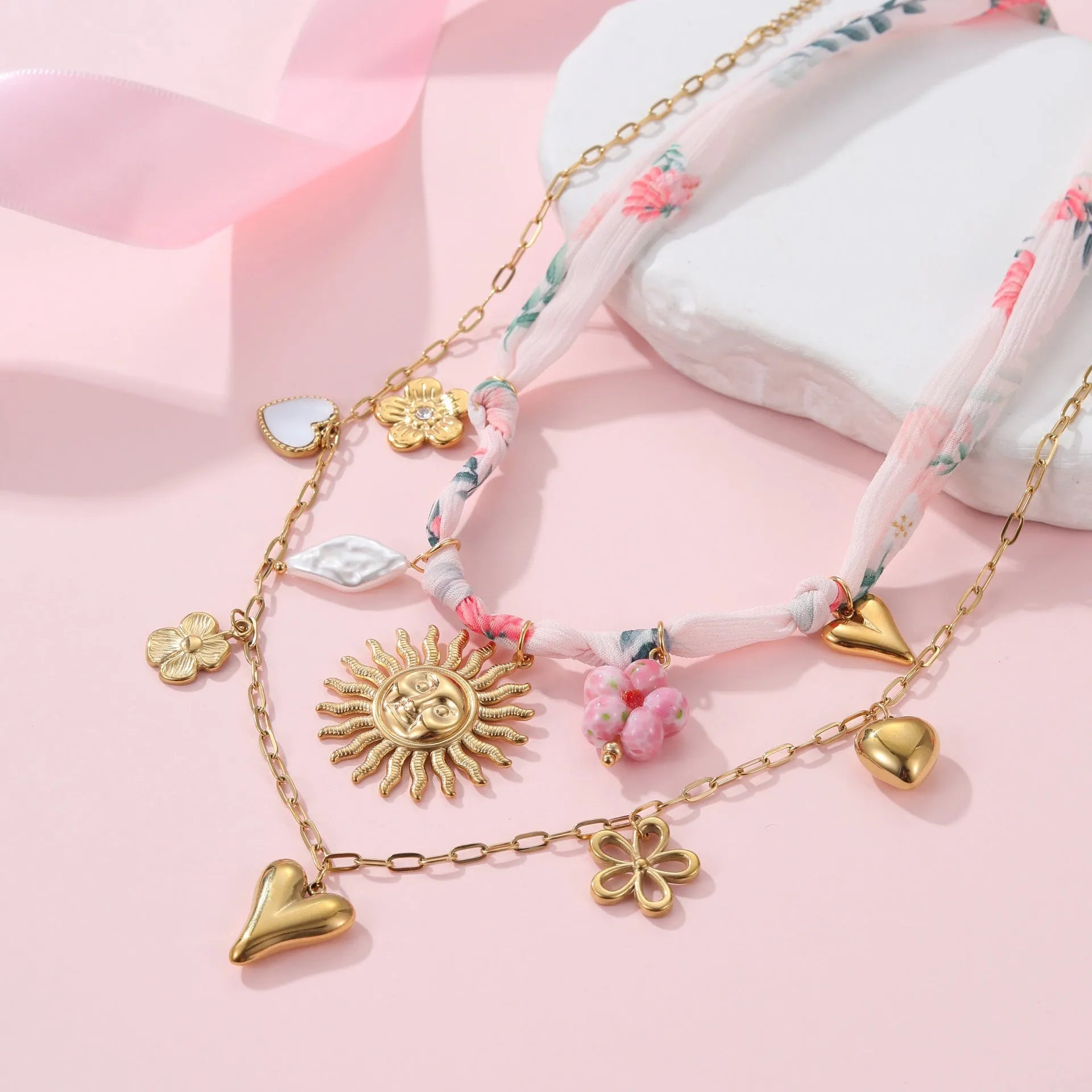 Gold-plated stainless steel necklace showing geometric sun pendant on an adjustable chain.