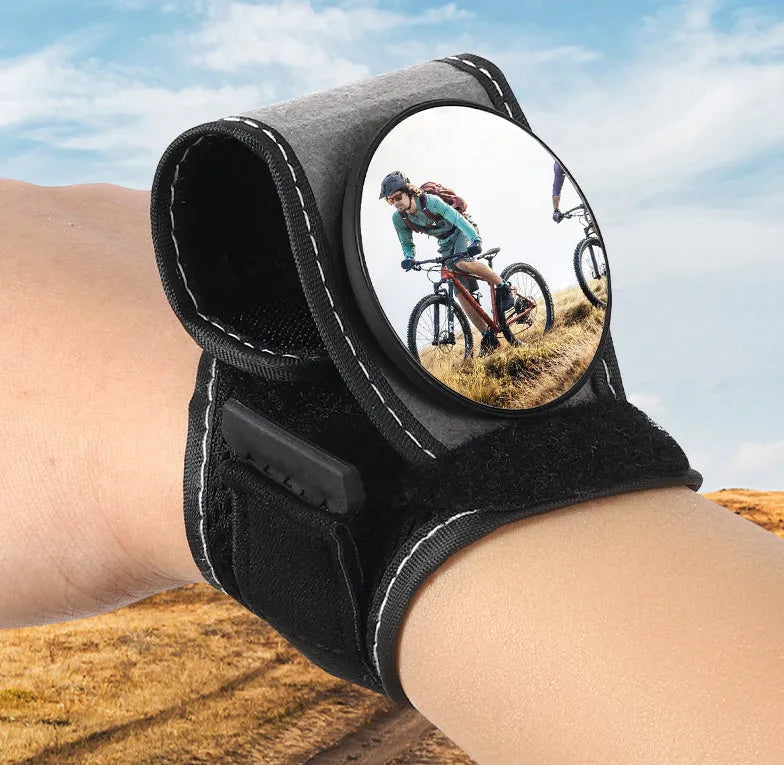 Black nylon wrist-mounted rear-view mirror for bicycles on a cyclist's wrist.