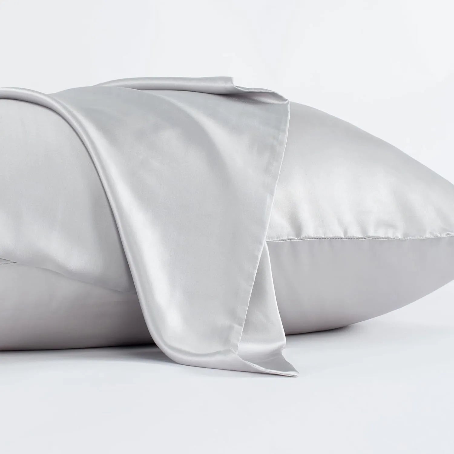 Dark grey envelope closure silk pillowcase on a bed.